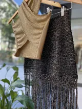 Falda tejida a mano en crochet, color crudo, con flecos en el ruedo y abertura lateral.