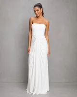 Vestido largo blanco strapless con drapeado frontal y silueta fluida, confeccionado en tela alicrada de alta calidad.