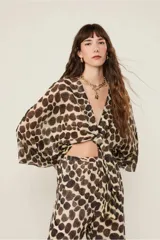 Blusa estampada con corte holgado, largo medio, abotonadura frontal y escote en V. Se puede llevar con un lazo en el bajo.