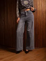 Pantalón de jean corte wide leg, color gris lavado, con tiro alto, cierre frontal con botón y bolsillos laterales.