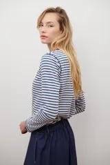 Remera de manga larga con diseño de rayas horizontales en azul y blanco, destacada por un cuello redondo en color bordó con costuras a la vista.