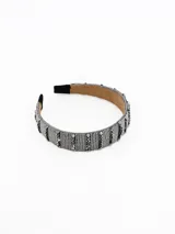 Vincha rígida forrada con tejido de cuentas metálicas plateadas y cristales facetados en tonos grises, con interior de gamuza suave.