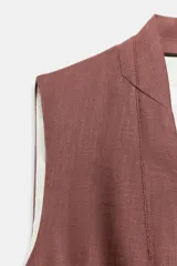 Chaleco de lino color marrón, sin mangas, con escote en V, solapa sutil, cierre frontal con botones oscuros y bolsillos de vivo simulados.