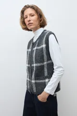 Chaleco de punto jacquard con diseño de cuadros, cuello redondo y cierre frontal con botones.