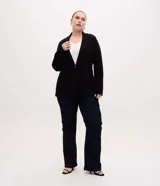 Blazer negro de corte slim alargado, confeccionado en punto roma con abotonado doble frontal, solapas de muesca y bolsillos de ojal en los laterales.