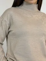Buzo de cuello alto en color camel, confeccionado en tejido de punto con diseño de corte relajado y terminaciones acanaladas en puños y ruedo.