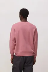 Sweater de punto de cuello redondo y manga larga, con diseño minimalista y logo pequeño bordado en el pecho.