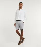 Bermuda de hombre de corte recto, confeccionada en una mezcla de lino y algodón con textura discreta. Presenta cintura con trabillas, cierre frontal con botón y cremallera, y dos bolsillos laterales.