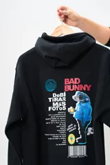 Buzo canguro negro con capucha y cordones ajustables. Estampado en la espalda con la imagen de un personaje de caricatura y el texto "Bad Bunny".