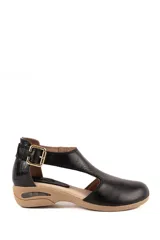 Sandalias de cuero negro con talón texturizado, puntera cerrada, tira en T y hebilla metálica dorada lateral. Suela de goma color tostado con tacón bajo y diseño ergonómico.