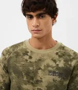 Remera de manga larga confeccionada en tejido waffle con textura. Presenta diseño camuflado en tonos verdes y estampa frontal con lettering Natural Balance.