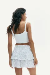 Minifalda blanca con estampado floral azul, cintura elastizada y corte escalonado con volados.