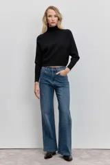 Pantalón de jean corte wide leg, color azul medio, con detalle de strass aplicado en toda la superficie frontal. Cuenta con tiro medio, cierre frontal con botón y bolsillos laterales y traseros.