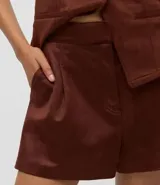 Short femenino de corte evasé confeccionado en gamuza sintética, con cintura fija, pliegues delanteros y bolsillos laterales tipo cuchillo.