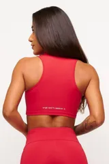 Top deportivo negro, estilo crop top, con cuello polo y escote en V. Presenta tirantes anchos y corte ajustado al cuerpo.