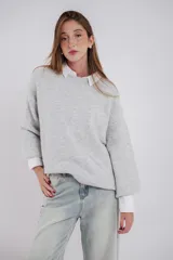 Buzo tejido color gris claro, de corte oversize y cuello redondo.