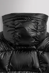 Campera puffer negra con capucha ajustable, cierre frontal con cremallera, bolsillos laterales con cremallera oculta y relleno de plumón y pluma.