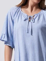 Blusa celeste y blanca a rayas verticales, de lino y corte holgado. Tiene cuello redondo con escote en V y lazo de ajuste. Las mangas son cortas y amplias, con volados en el borde.