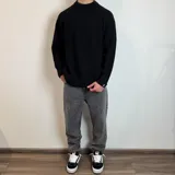 Sweater verde oliva de tejido grueso con cuello alto y mangas raglán. Corte holgado.