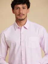 Camisa de corte regular fit, confeccionada en tejido oxford de algodón. Presenta cuello clásico, cierre frontal con botones y un bolsillo en el pecho.