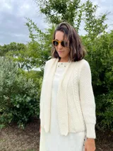 Cardigan tejido a mano color crudo, con solapa en el escote y punto delicado.