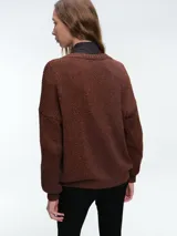 Cardigan de punto con hilo brillante, cuello en V y cierre frontal con botones. Presenta mangas largas con puños acanalados y un diseño de calce holgado.
