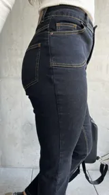 Pantalón de jean negro con costuras a la vista color ocre.