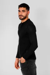 Remera de manga larga color negro, confeccionada en algodón, con cuello redondo y cierre frontal parcial con botones.