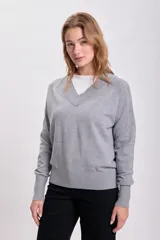 Sweater gris de tejido de punto con escote en V.