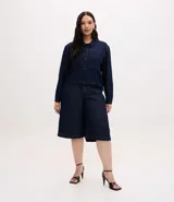 Campera de jean color azul oscuro, con diseño cropped, cuello clásico, mangas largas, cierre frontal con botones y dos bolsillos frontales grandes.