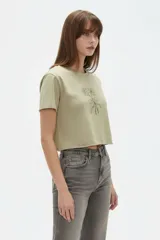 Remera cropped de algodón negra con cuello a la base, mangas cortas y estampado frontal de cerezas con la palabra "HELLO".
