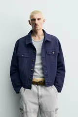 Cazadora relaxed fit de algodón en color azul marino con efecto lavado, cuello solapa, bolsillos con solapa en el pecho y cierre frontal con botones metálicos.