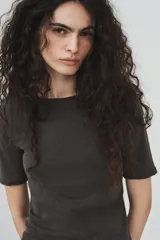 Camiseta de algodón color terracota con efecto lavado, cuello redondo y manga corta. Posee un bajo redondeado.