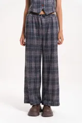 Pantalón de corte amplio y tiro medio con estampado a cuadros en tonos grises y detalles en naranja. Presenta cintura elastizada con cordón de ajuste frontal y diseño de pierna recta.