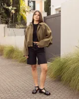 Sandalias de cuero negro charolado estilo romano, con tiras entrelazadas, tira en T y hebilla metálica de ajuste lateral.