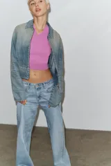 Jeans de tiro alto con diseño de pierna ancha y corte extra largo. Presenta cinco bolsillos clásicos y detalle de tachas metálicas a lo largo de las costuras laterales. Cierre frontal con cremallera y botón metálico.