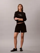 Shorts de felpa francesa color negro, con talle alto, cintura elástica y bolsillos laterales. Presenta el logo de la marca bordado en el bajo.