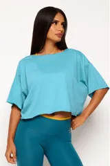 Remera corta de manga corta color celeste, con escote amplio en la espalda que se anuda en la parte inferior, dejando ver un top deportivo amarillo con tiras cruzadas.