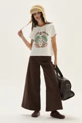 Remera blanca de algodón con cuello redondo y manga corta. Presenta un estampado central con dos unicornios enfrentados rodeados de follaje y el texto "MAGICAL DREAMS".