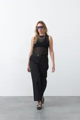 Top negro sin mangas, de tejido translúcido con rayas horizontales, cuello redondo y calce entallado.