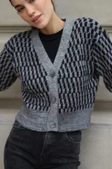 Cárdigan de tejido de punto con diseño geométrico en blanco, negro y beige. Corte recto, con botones al frente y lurex.