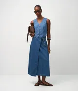 Pollera lápiz midi confeccionada en denim, con diseño cruzado al frente, cintura elastizada y lazo ajustable del mismo tejido.