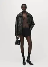 Cardigan de punto fino con diseño recto y textura de canalé. Presenta cuello de pico, cierre frontal con botones y mangas largas.