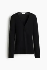 Top de manga larga de punto acanalado fino, de color negro, con ajuste ceñido al cuerpo, escote en V y cierre frontal parcial con corchetes ocultos.