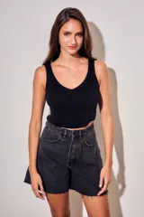 Bermuda de jean estilo wide leg, color negro lavado, con tiro medio, bolsillos laterales y ruedo desflecado.