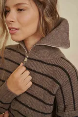 Buzo de tejido de punto con diseño a rayas horizontales, cuello alto con cierre frontal y mangas largas.
