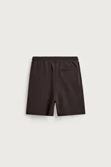 Bermuda estilo jogger de ajuste relajado, color negro, confeccionada en tejido interlock de algodón. Cuenta con cintura elástica ajustable mediante cordón, bolsillos delanteros tipo vivo y diseño liso.