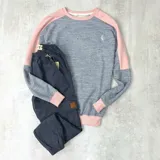 Buzo gris con mangas y cuello rosado claro, confeccionado en algodón rústico.