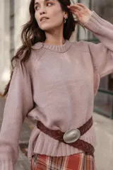 Buzo de lana color rosado, con cuello redondo, mangas largas y diseño holgado.