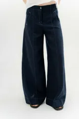 Pantalón de lino con algodón, color azul marino, de tiro medio y piernas anchas. Cuenta con dos bolsillos delanteros y dos traseros con detalles de remaches y atraques.